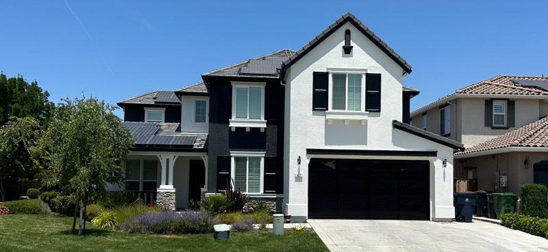 Residential painting Front view of house with white exterior and black accents.
