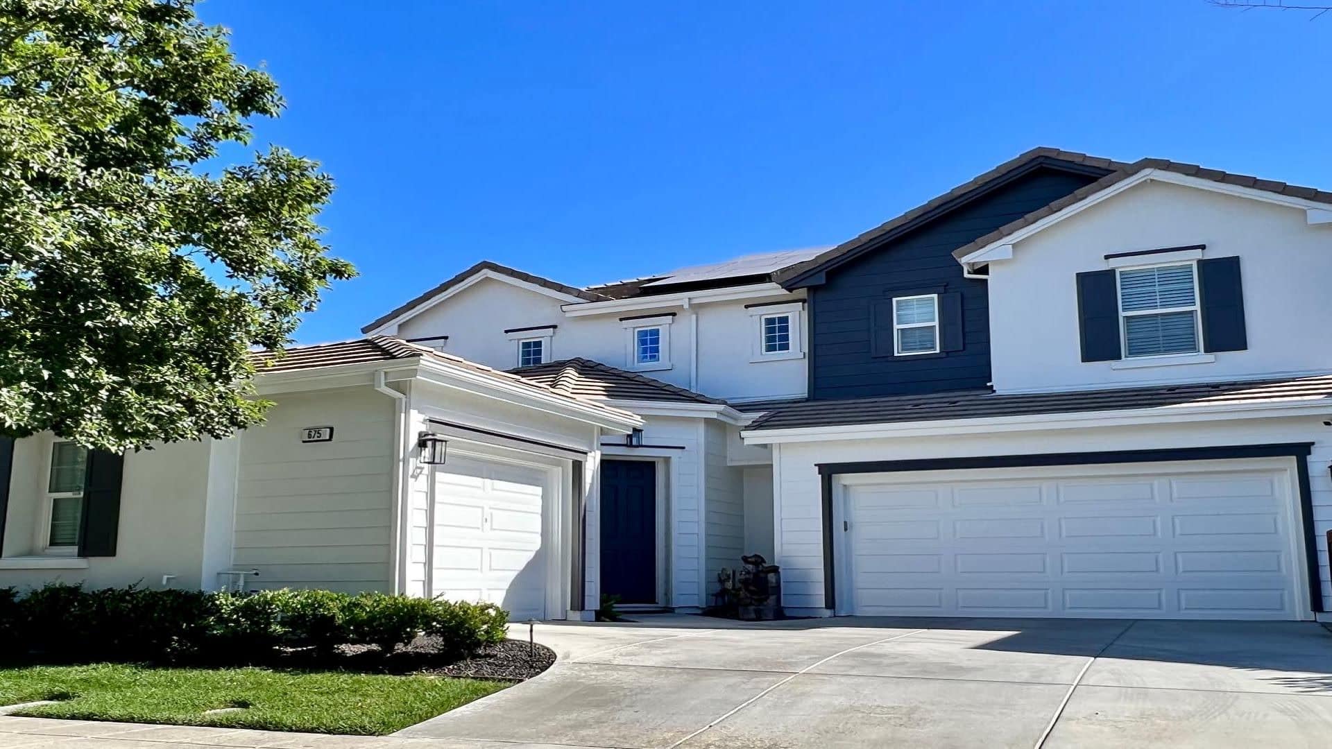 White house exterior with dark gray accent facade. best exterior paint colors